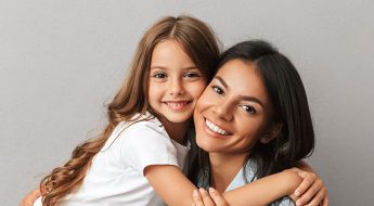 madre e hija sonriendo para introducir post "Estética dental en adolescentes y adultos"