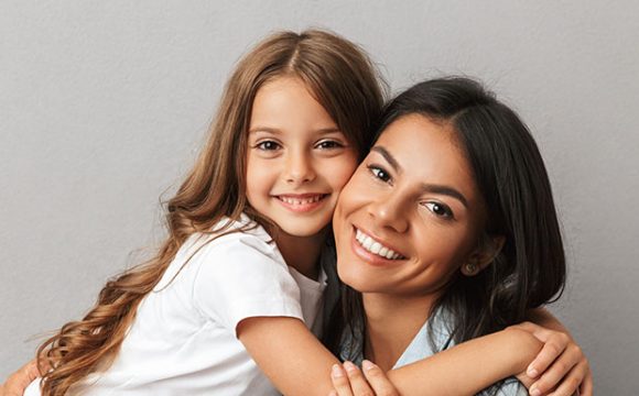 madre e hija sonriendo para introducir post "Estética dental en adolescentes y adultos"